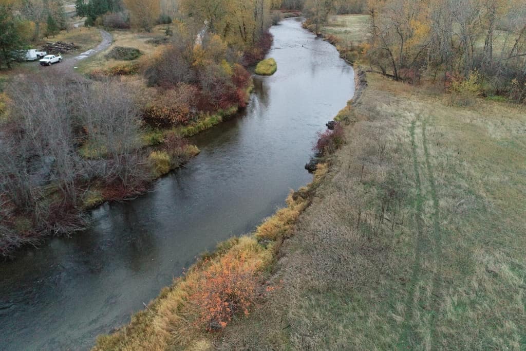 Aerial view of the Jocko River curving past a grassy floodplain
