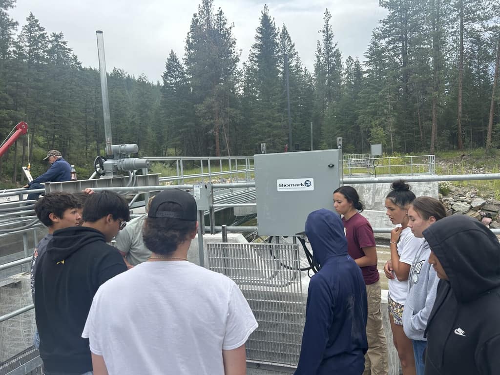 Students gathered around fish screen equipment at a DEWR facility